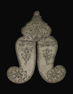 Circumcision-plate; silver; thin; both faces engraved with inscriptions, quatrefoils, floral scrolls and rosettes.